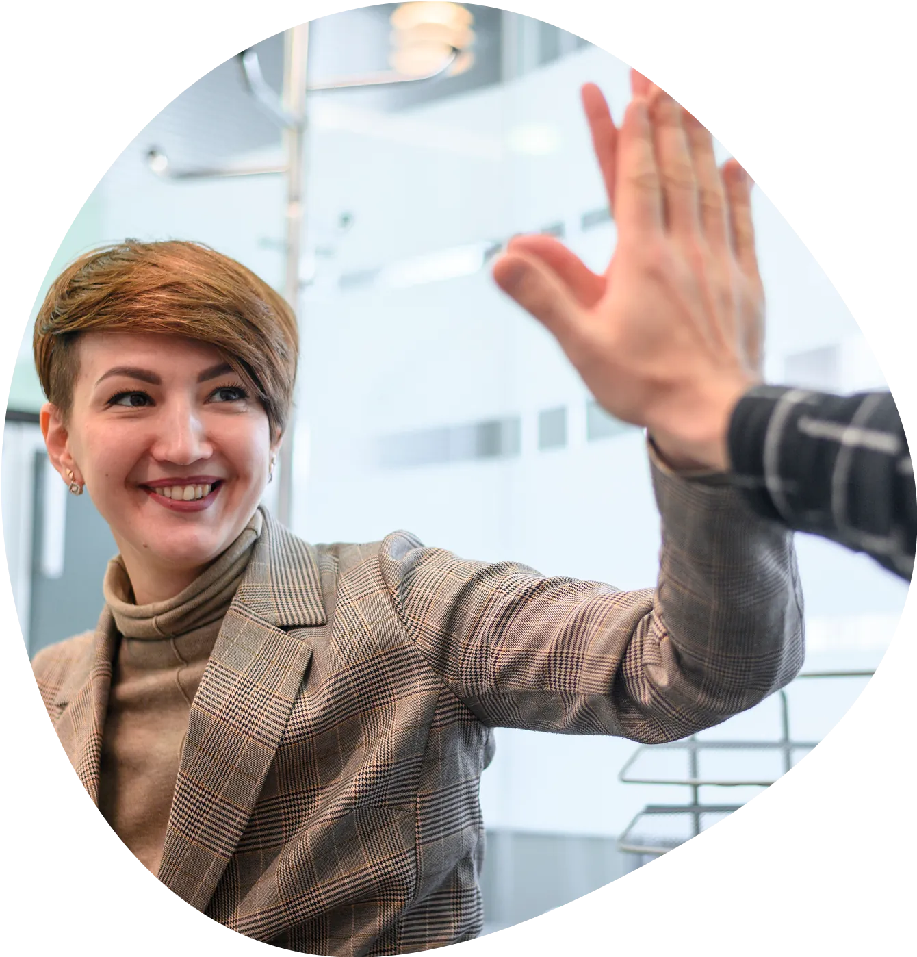 A smiling woman gives a colleague a high five